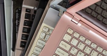 Gebrauchte Elektrogeräte – Top oder Flop? Mehrere übereinander liegende Laptops in verschiedenen Farben