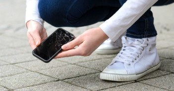 Handy kaputt – und nun? Die häufigsten Handyschäden und ihre Vorbeugungsmöglichkeiten Person hebt kaputtes Handy auf