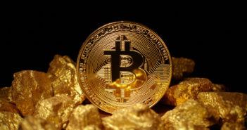 KaratBank Coin: Münze einer Kryptowährung liegt auf Gold Nuggets
