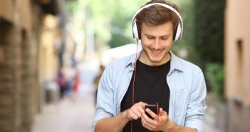 Mann benutzt Prepaidhandy mit mp3 Player