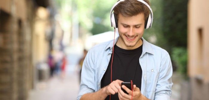 Mann benutzt Prepaidhandy mit mp3 Player