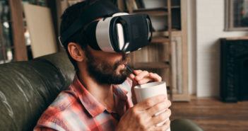 Mann mit einer Virtual Reality Brille auf dem Sofa
