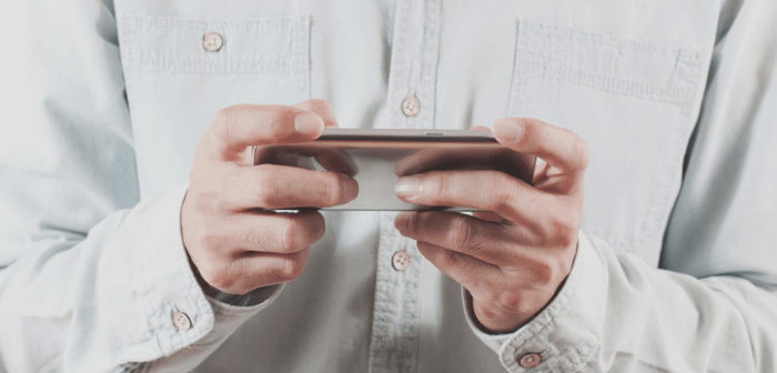 Männliche Person, die auf dem Smartphone spielt