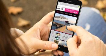 Eine Frau liest Trends auf ihrem Smartphone (Schulterperspektive)