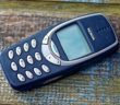 Nokia 3310 Mobiltelefon liegt auf Holzgrund