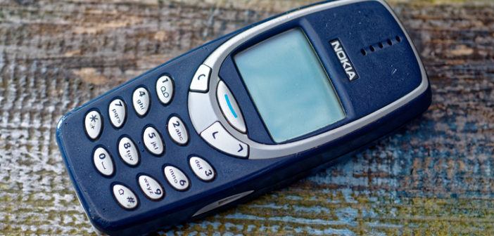 Nokia 3310 Mobiltelefon liegt auf Holzgrund