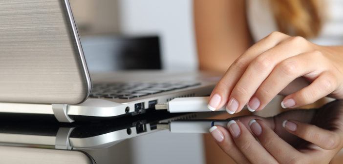 Frau steckt Surfstick in Laptop