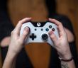 Draufsicht, wie ein Mann einen weißen XBox-Controller hält