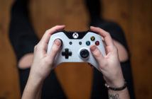 Draufsicht, wie ein Mann einen weißen XBox-Controller hält