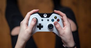 Draufsicht, wie ein Mann einen weißen XBox-Controller hält