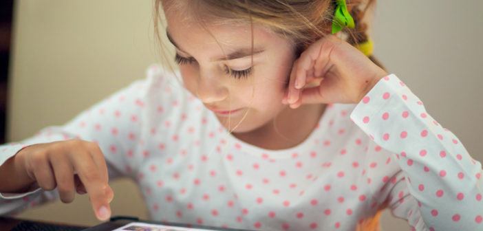 Kind programmiert Lernroboter am Tablet