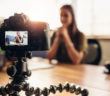 Frau filmt sich mit einer DSLR Kamera