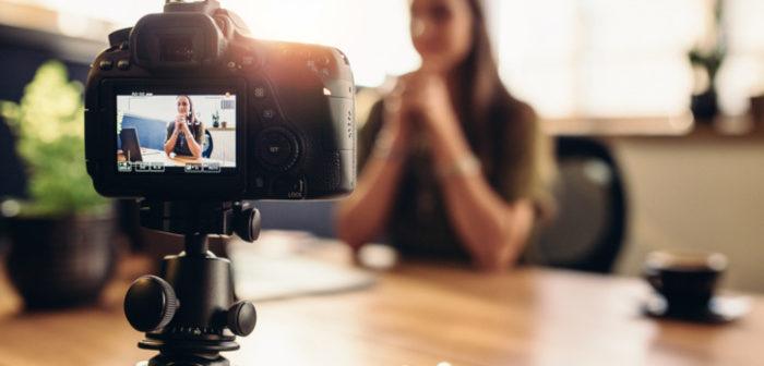Frau filmt sich mit einer DSLR Kamera