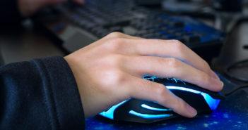 Nahaufnahme eines jungen Mannes, wie er eine Computermaus nutzt