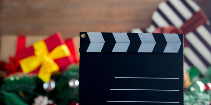 Filmklappe vor Weihnachtsdeko und Geschenken
