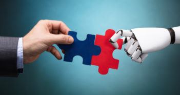 Menschliche Hand reicht einem Roboter die Hand