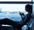 Frau mit Smartphone am Flughafen