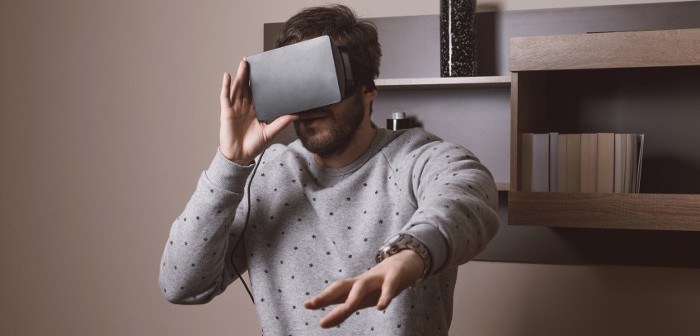 Mann trägt eine Oculus Rfit VR Brille in einem Wohnraum