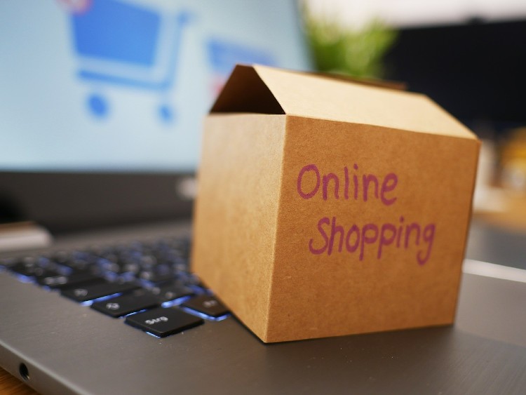 Ein Paket mit Beschriftung "online Shopping" steht auf einem Laptop